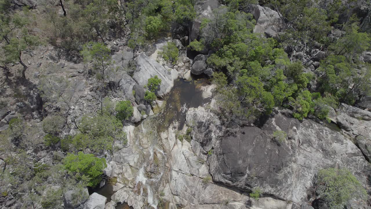 vista de arriba hacia abajo de las cascadas de agua en las cataratas de emerald creek en mareeba, australia durante el día - toma aérea de drones