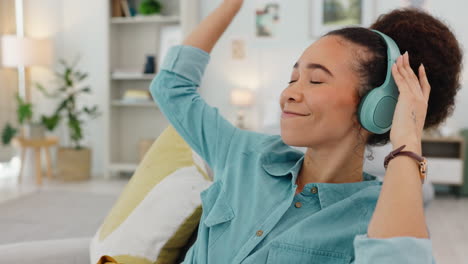 music, headphones and woman dance on sofa in home