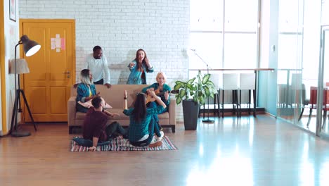 company of friends of different nationalities sing songs and play guitar in a large modern studio