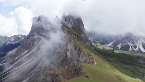 Aerial-over-Seceda-Ridgeline-toward-Fermeda-Towers-in-clouds,-Puez-Odle,-Italy