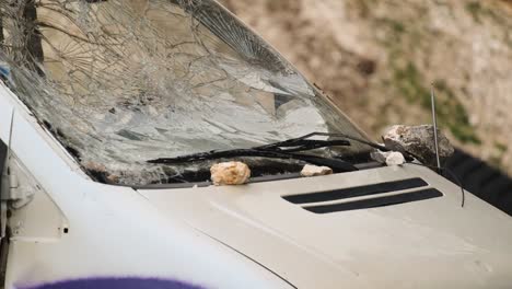 la ventana delantera de una camioneta vieja destrozada por rocas