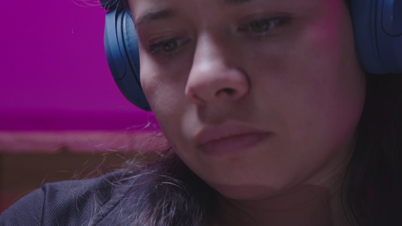 A writer develops her ideas, listening to music for inspiration while writing in a journal. The flat color profile makes this a versatile asset for any project about the creative process