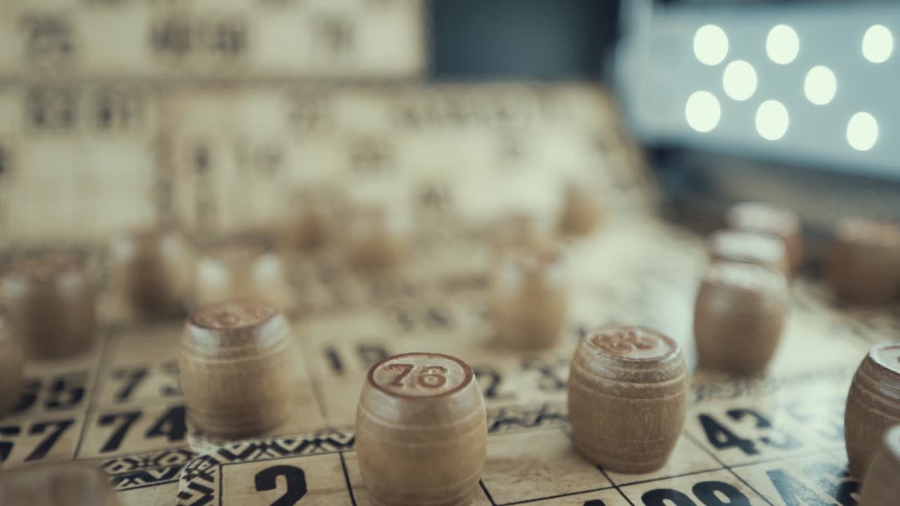 Macro video of a Bingo board, studio lights, 120 fps, slow motion, wooden chip digits, Raw footage, lottery desk game, card numbers, pull back movement