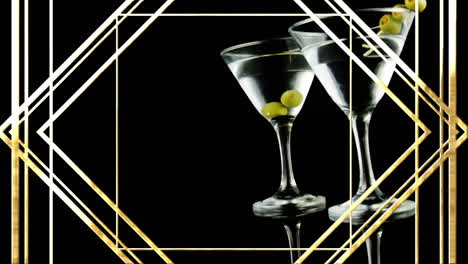 golden frame design pattern over olives in two cocktail glasses against black background