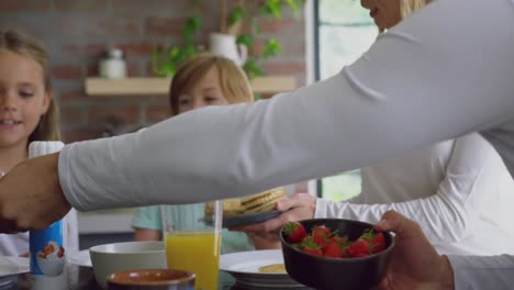 Familie-Beim-Essen-Am-Esstisch-In-Der-Küche-Im-Komfortablen-Zuhause-4k