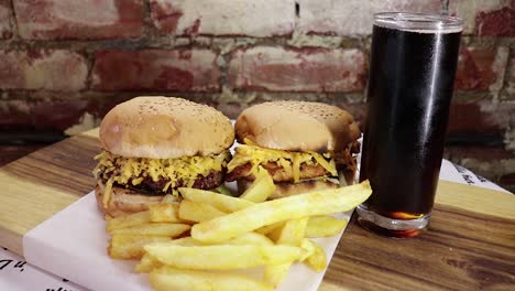 hand-held-wide-shot-of-beef-and-chicken-burgers-on-wooden-board