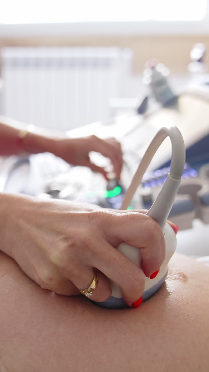 Obstetric ultrasound scans. Ultrasound investigation of a pregnant woman. Doctor doing sonography procedure on female's belly in clinic. Healthcare concept. Vertical video