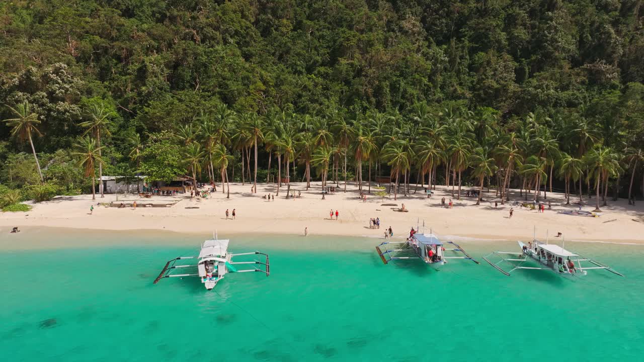 Una vista da drone che scorre a sinistra mostra il turismo della baia turchese e lo stile di vita dell'isola di El Nido.