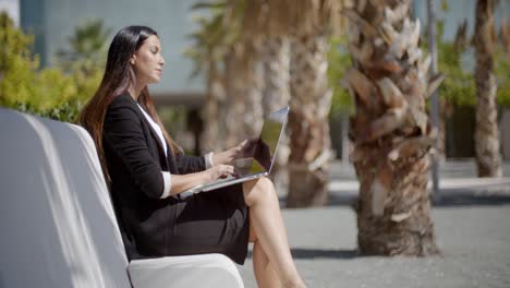 Businesswoman-sitting-working-in-an-urban-park