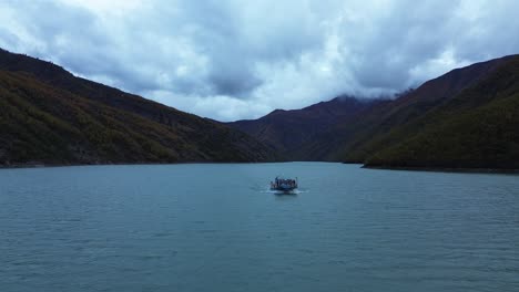 Vista-Aérea-Del-Barco-Navegando-Por-El-Lago-Komani-Con-Un-Paisaje-Montañoso-Pintoresco.