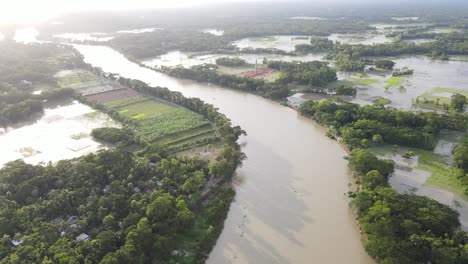 flooded fields beside river tributary in due to rising climate change with bright afternoon sun shining