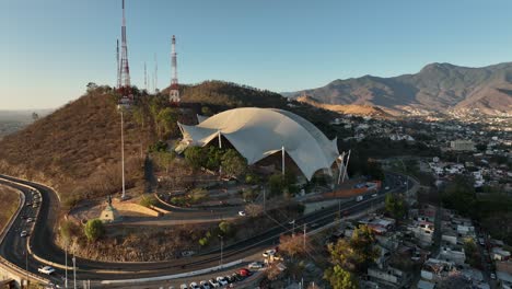 Luftaufnahme,-Guelaguetza-Auditorium-Und-Verkehr-Auf-Der-Panamericana,-Oaxaca,-Mexiko,-Filmische-Drohnenaufnahme