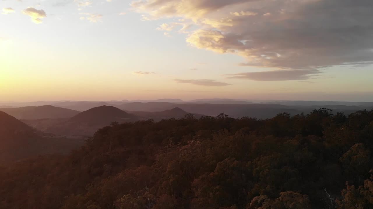 vuelo de drones sobre el paisaje interior australiano al atardecer, con árboles y nubes