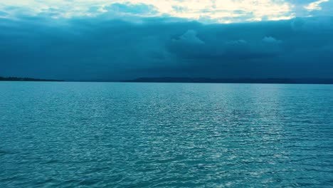 sunset on the lake with clouds, drone flies on low altitude over the lake