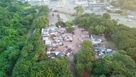 aerial view of a home made shacks squatter camp next to a canal surrounded by bushes on the bluff in durban south africa