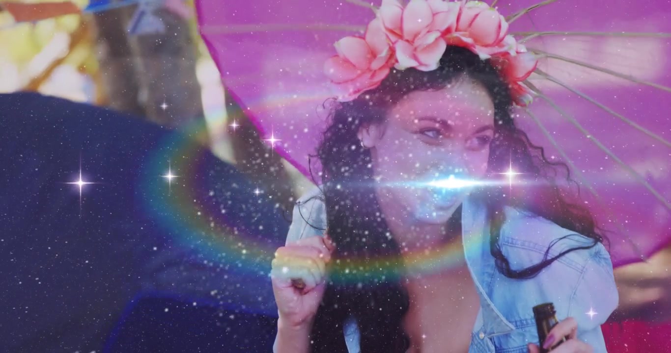 Woman chatting off-camera and initiating sparkles plus rainbow lens flare for festival marketing