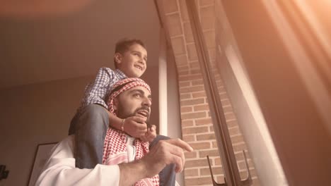arabic son and his and her father looking through the window. isolation at home for self quarantine. concept home quarantine, prevention covid-19. coronavirus outbreak situation