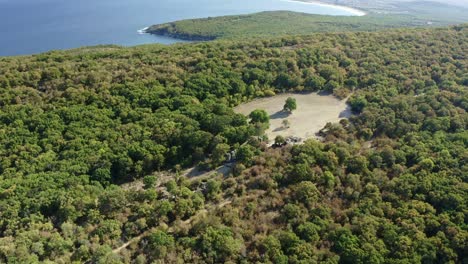 Drone-Acercándose-A-Las-Antiguas-Formaciones-Rocosas-Prehistóricas-De-Beglik-Tash-En-Medio-De-Un-Bosque-Y-El-Mar-Negro-En-La-Distancia-Como-Fondo,-En-Bulgaria