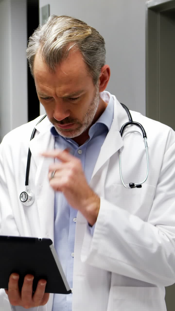 Medico maschio che per mezzo della compressa digitale