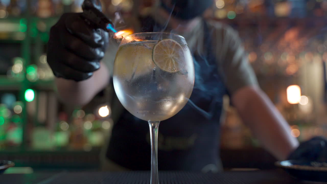barista latino che fuma tonico di vodka agli agrumi fiammeggiante bar sfondo sfocato