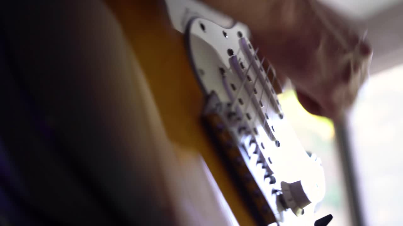 Müzisyenin elektrik gitarını çalarken ellerinin alçak açı çekim detayı