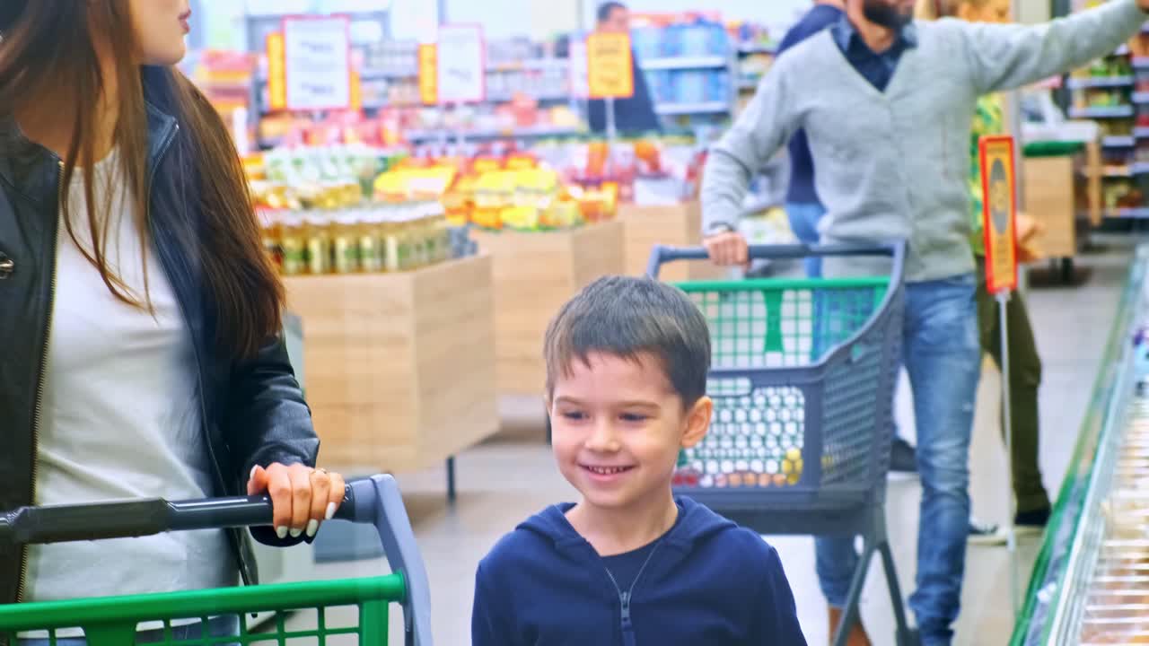 A Busy Supermarket Scene Featuring Families Shopping Together, Children Exploring Aisles, and Adults Selecting Fresh Produce in a Brightly Lit Environment