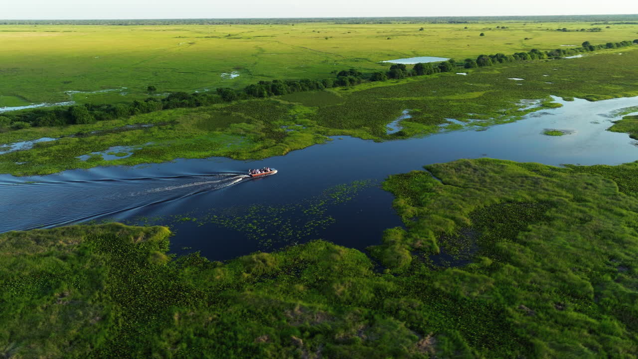 vista aérea sobre personas en un paseo en barco en el río los llanos en venezuela al atardecer - toma de dron