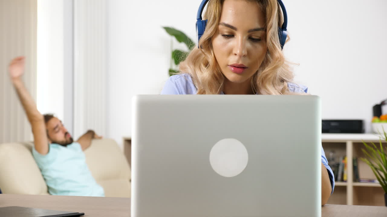 Woman working from home with laptop and headphones