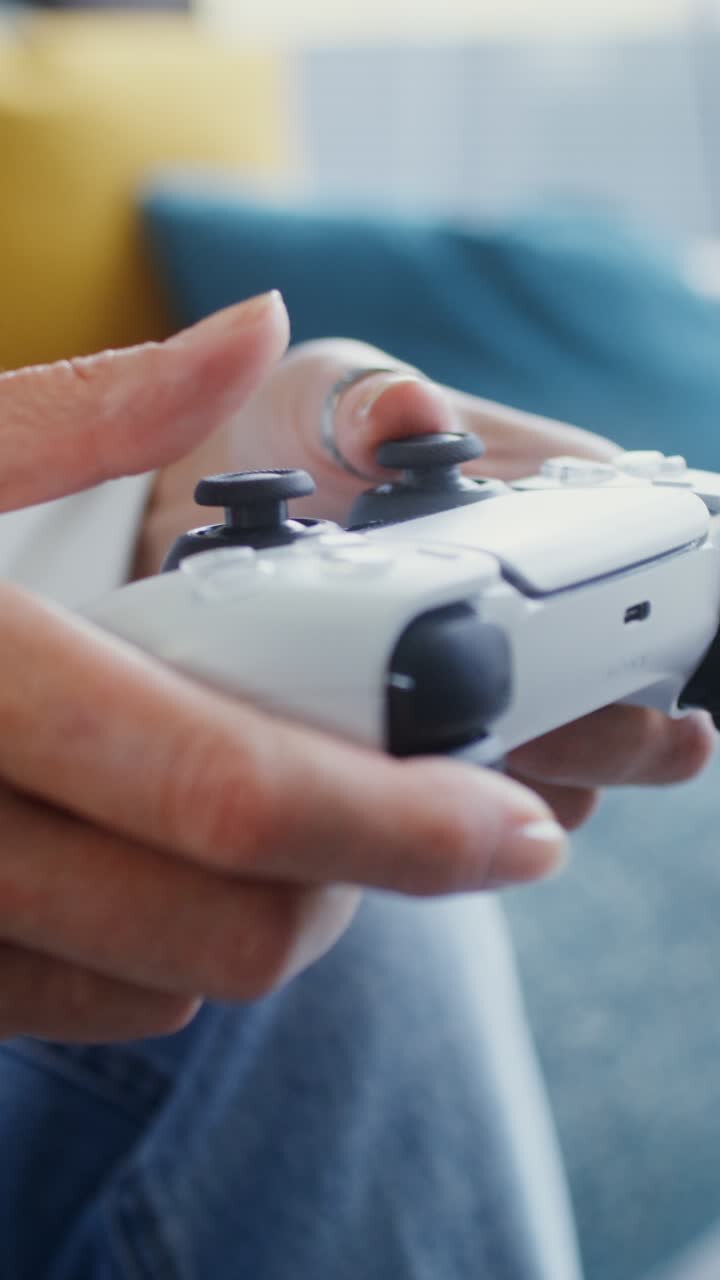 Close up of hands holding a PlayStation Dual Sense controller