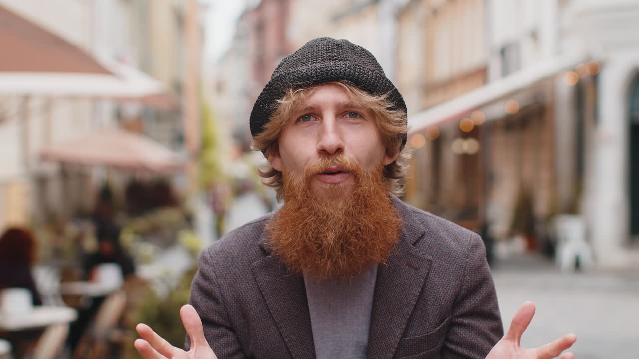 Young man looking surprised at camera shocked by sudden win good victory news wow in city street
