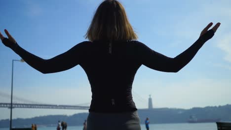 Athletic-young-woman-standing-at-riverside