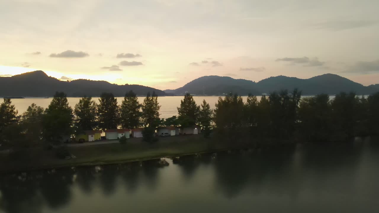 Pengambilan gambar panning ke kiri pemandangan matahari terbenam perairan di Pulau Marina, Malaysia