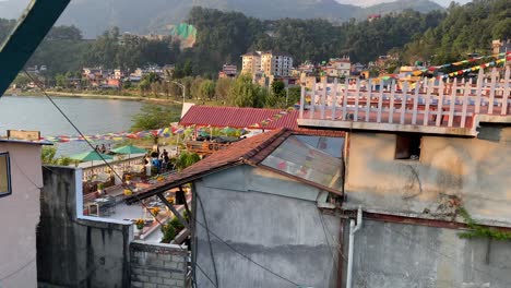 Montando-En-Una-Antigua-Noria-Sobre-La-Pequeña-Ciudad-De-Pokhara,-Nepal,-A-La-Luz-Del-Atardecer-Con-Las-Montañas-Al-Fondo.