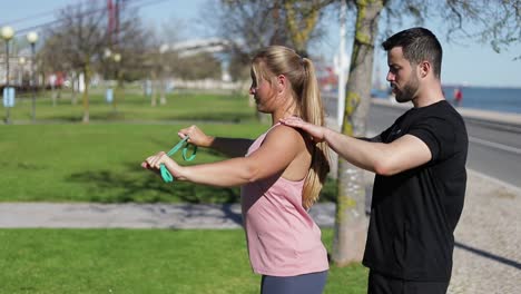 Beautiful-blonde-training-under-guidance-of-coach-in-summer-park.