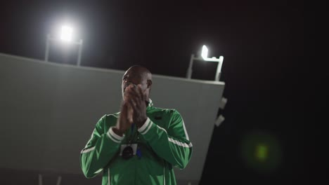 african american male coach clapping watching disabled male athlete with running blade training