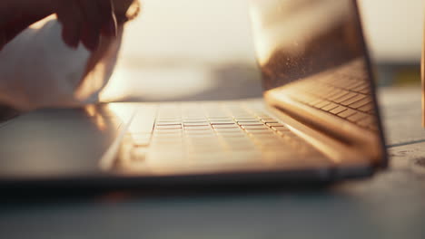 woman working on laptop outdoors at sunset