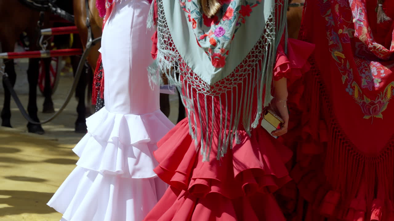 Group of friends in matching flamenco dresses sharing laughs at the Seville fair