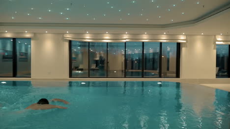 man swimming alone in the indoor pool