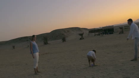 Parents-and-son-playing-football-on-the-beach