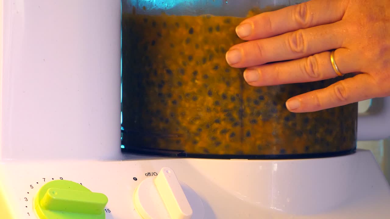 mezclador de alimentos con pulpa de fruta de la pasión siendo girada en el interior
