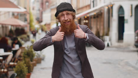 Young man showing thumbs up like sign positive something good positive feedback in city street