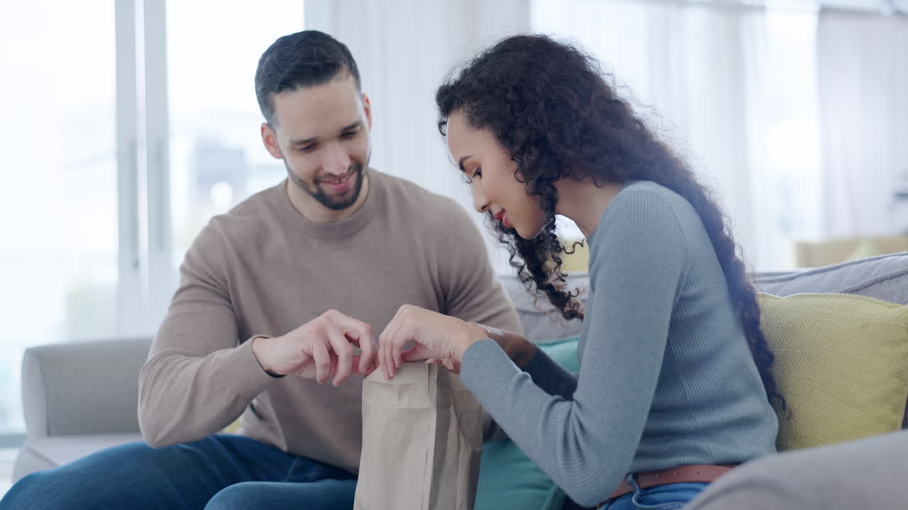 pareja, bolsa de papel y feliz en el sofá