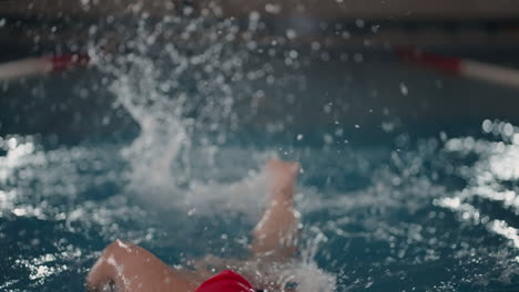 woman in red swim cap training in indoor swimming pool