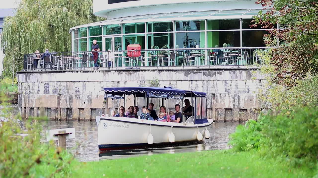 Group of people having a day out on a boat navigating the River Wey at Guildford in Surrey, England.