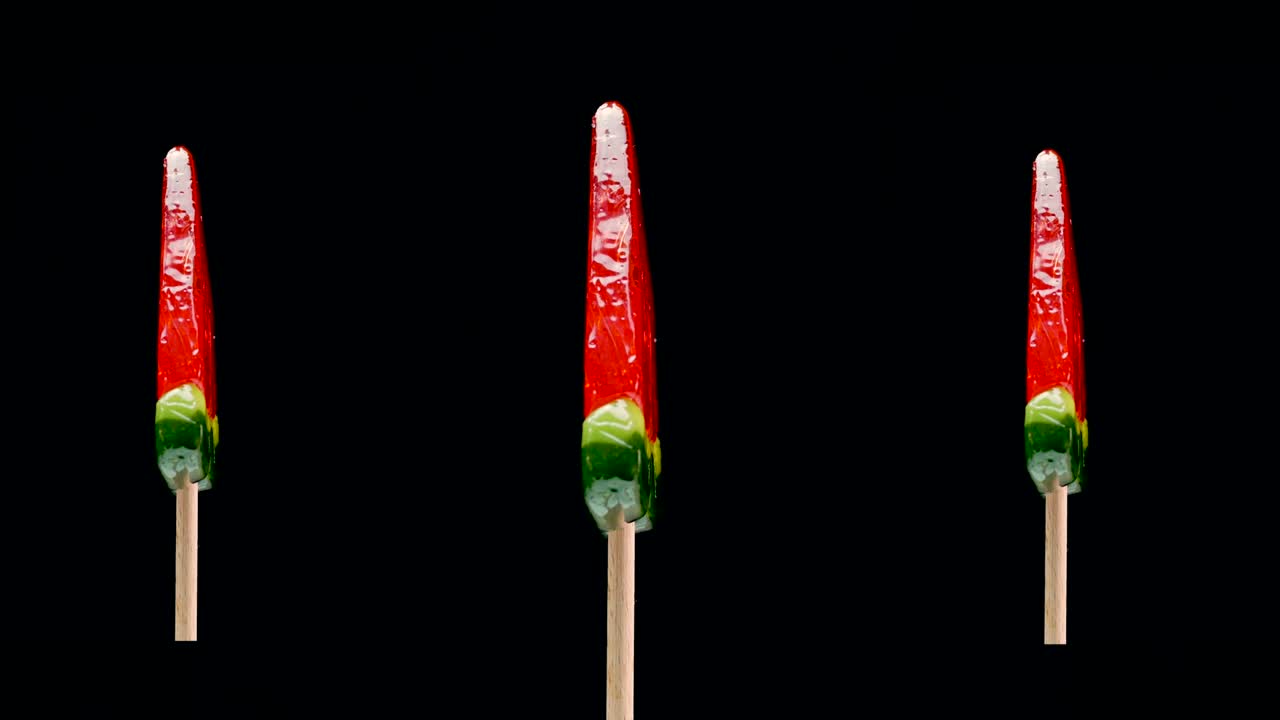 빨간색 릴리팝이 검은색 배경에 회전하고, 수박과 카라멜 릴리이 어린이들을 위해 달합니다.