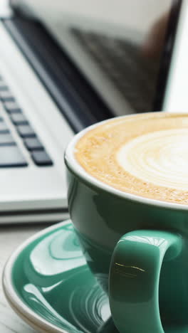 hombre usando una computadora portátil mientras bebe café