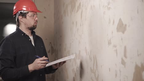 construction worker inspecting a wall