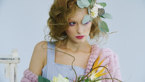 mannequin avec des cheveux avec des fleurs vivantes posant devant la caméra