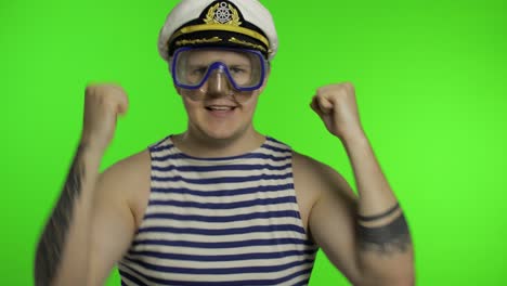 emotional man tourist in underwater mask, striped sailor shirt dances celebrates