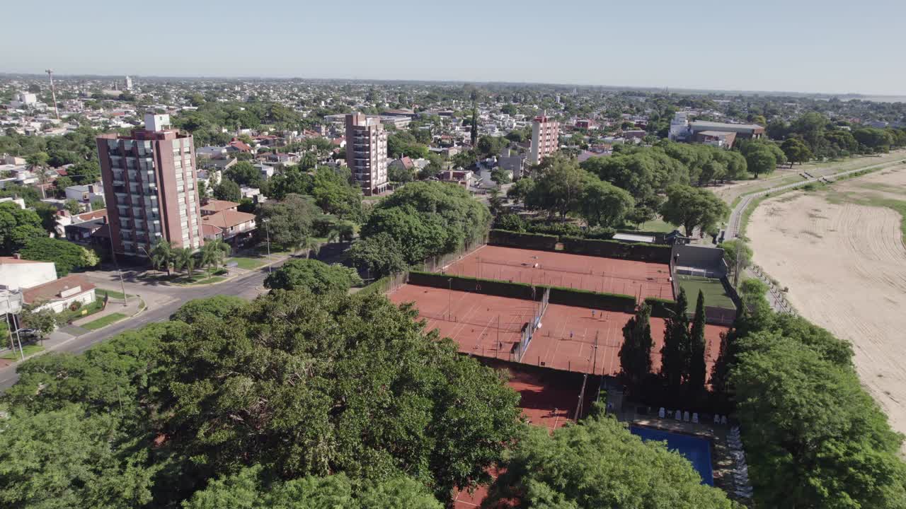 Aerial view of tennis complex in city near lagoon